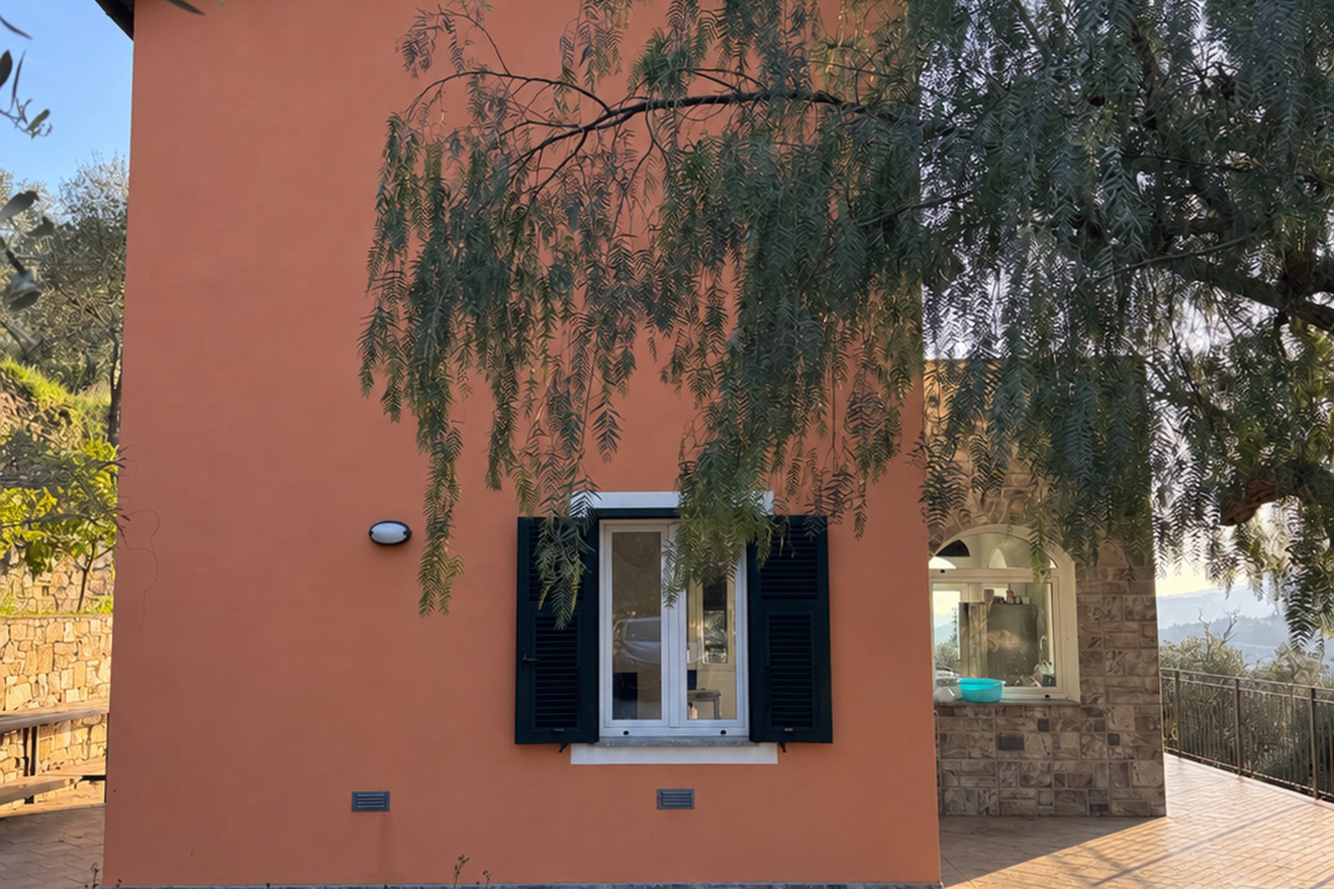 Unser Vorderhaus in Terrakotta mit dem Pfefferbaum im warmen Abendlicht